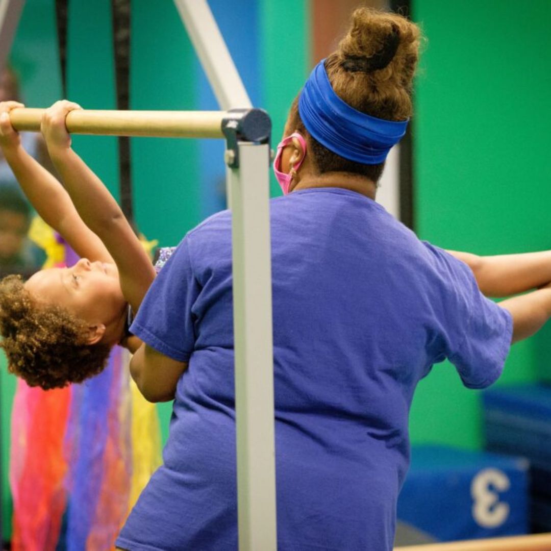 Gymnast on a bar with coach