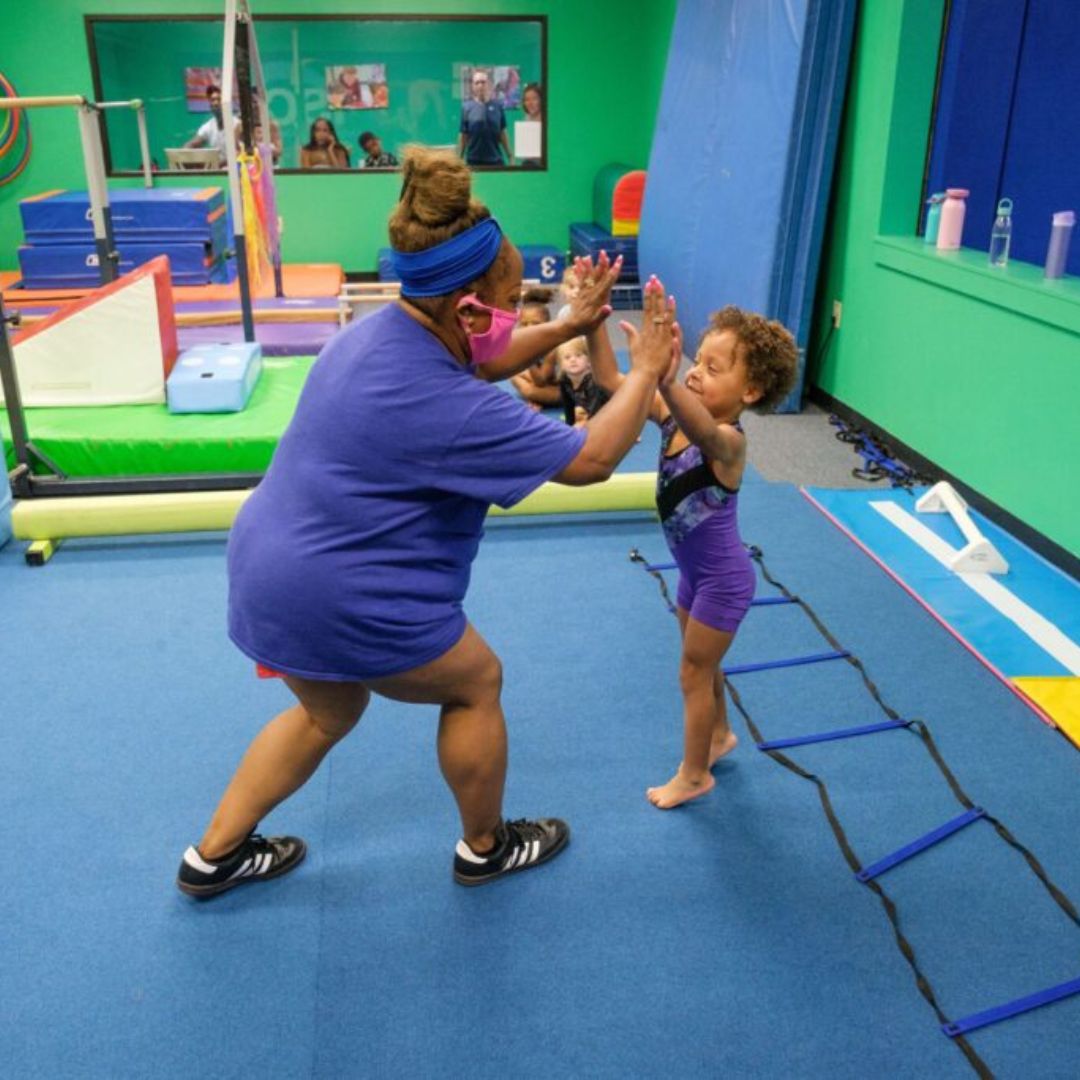 Coach giving gymnast high fives