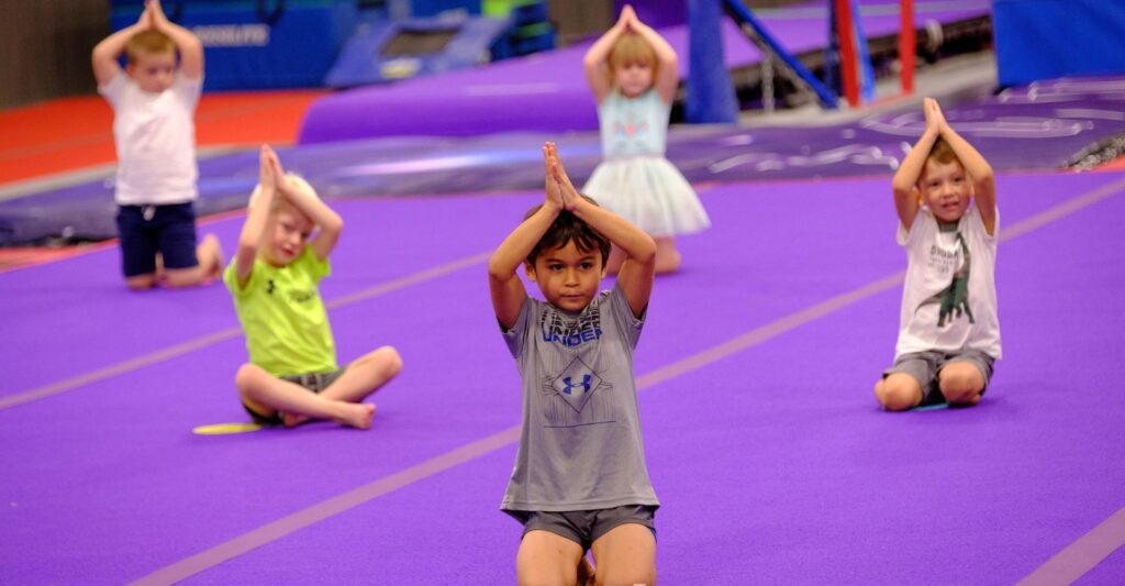 girls in gymnastics class stretching