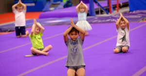 girls in gymnastics class stretching