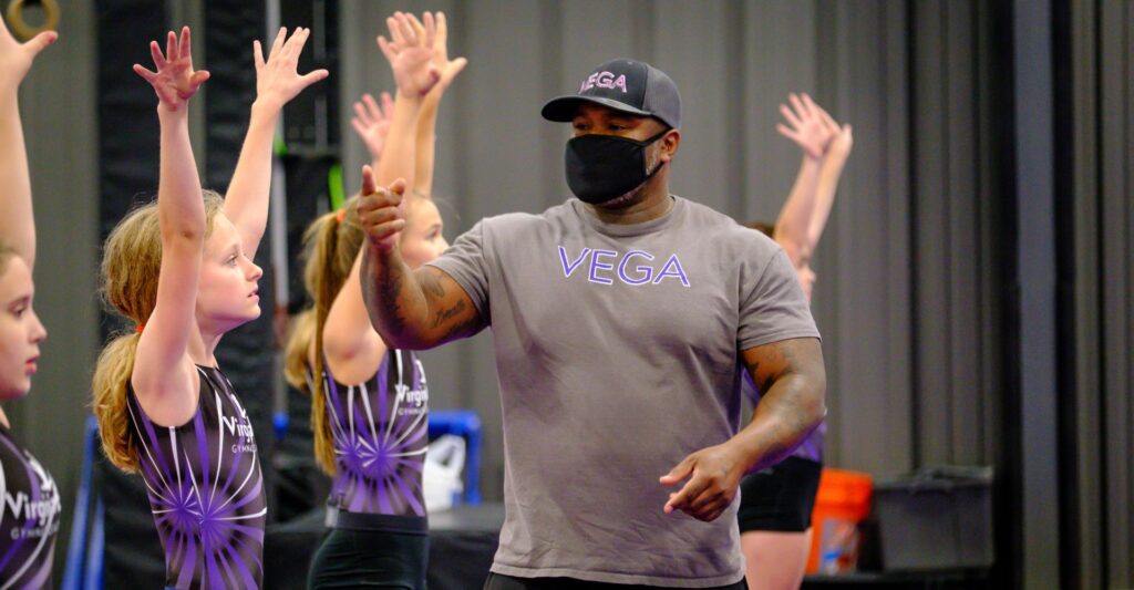 coach walking by high-fiving gymnasts